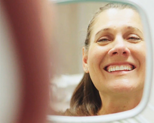 Paciente de Dental Expression apreciando los resultados de su trabajo dental